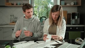 Worried couple calculating domestic bills and counting remaining money, Worried man and woman sitting at kitchen table and planning family budget. Concept of rising costs in households - Powered by Shutterstock - Get 15% off with code: PIKWIZARD15