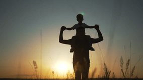 Happy family plays at sunset. Father carries child on shoulders. Family bonding in nature. Silhouette of father and child playing. Family enjoys sunset walk together. Playful moments in scenic nature. - Powered by Shutterstock - Get 15% off with code: PIKWIZARD15
