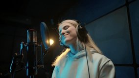 Funny young woman singing song in recording studio, portrait of female singer. Talent and professionalism, recording new hip-hop hit or voice acting, Caucasian lady speaking or singing loudly to mic - Powered by Shutterstock - Get 15% off with code: PIKWIZARD15