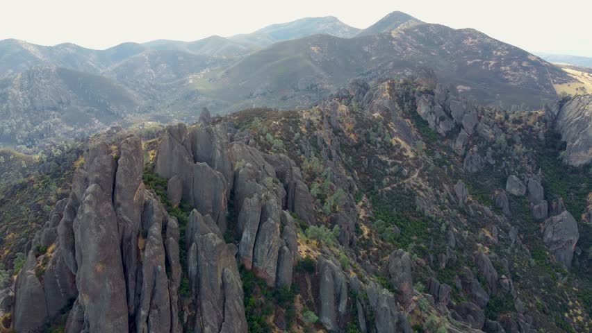 A drone view of a rocky mountain landscape under a misty sky in Pinnacles National Park, California, United States