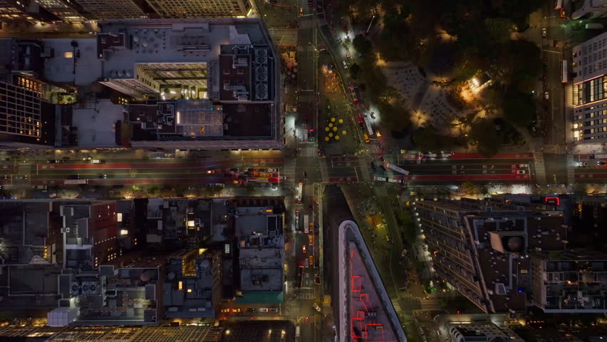 Tripod view from a unique crane perspective of traffic on a busy intersection at night in New York City,Madison Square Park in NoMad and Rose hill neighborhood