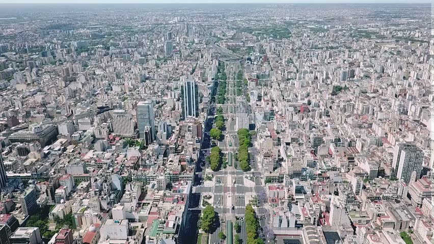 Camera moves forward over avenida 9 de julio, showcasing a clear sky and vibrant urban scenery in buenos aires, argentina