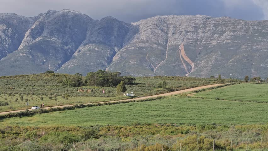 Mountainous landscape near Tulbagh with farmland and dirt roads under cloudy skies