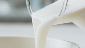 Pouring kefir yogurt into glass cup close-up. Glass with kefir or milk, lactic acid product dairy products concept. Drinking fresh lactose free in morning. - Powered by Shutterstock - Get 15% off with code: PIKWIZARD15