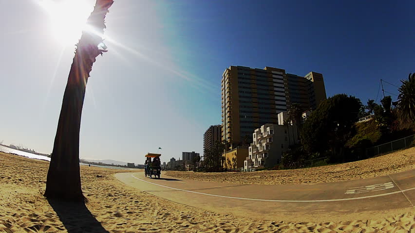 LONG BEACH, CA - APRIL 2, 2013: A family peddles a bike surrey or carriage along