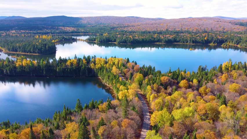 Calm Lake Surrounding Mont Tremblant in Quebec, Wide Aerial Drone Shot