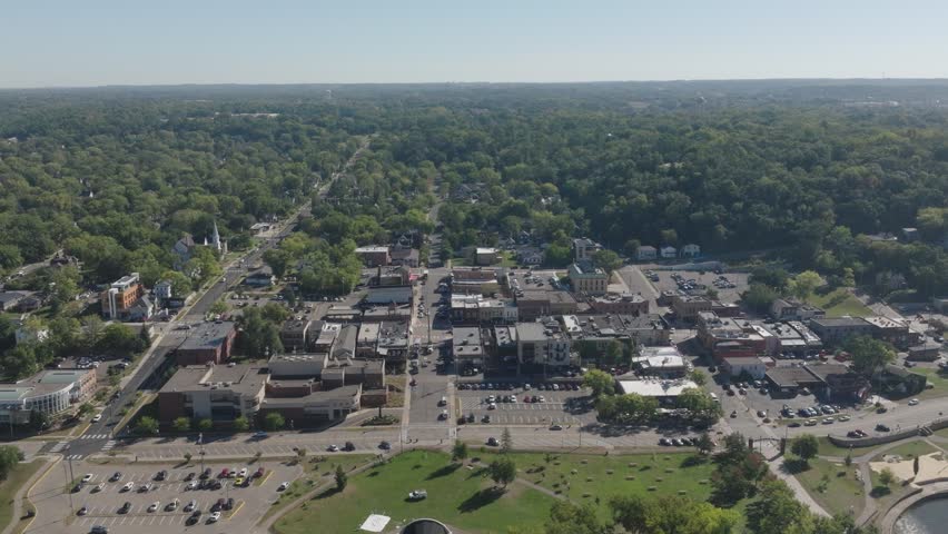 Aerial footage of Downtown Hudson Wisconsin surrounded in greenery in USA during morning.