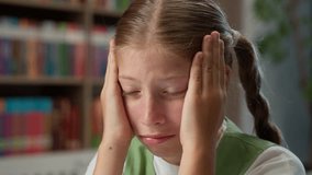 Close up sleepy sad Caucasian little girl school child kid schoolgirl tired bored teenage learner student exhausted pupil touching head rubbing eyes massage temples insomnia headache inside classroom - Powered by Shutterstock - Get 15% off with code: PIKWIZARD15