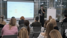 Business presentation with audience focusing on speaker. Professional environment, modern office setting. - Powered by Shutterstock - Get 15% off with code: PIKWIZARD15