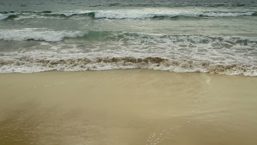 Beautiful sandy beach with small waves rolling in on the shore in California,