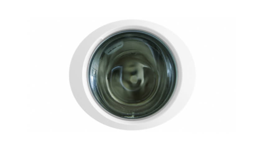 Clothes seen through door window on washing machine. Camera zooms through to a