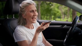 Happy smiling Caucasian elderly senior mature female woman laughing auto car driver pensioner inside automobile use mobile phone online app talking call recording voice message smartphone speakerphone - Powered by Shutterstock - Get 15% off with code: PIKWIZARD15