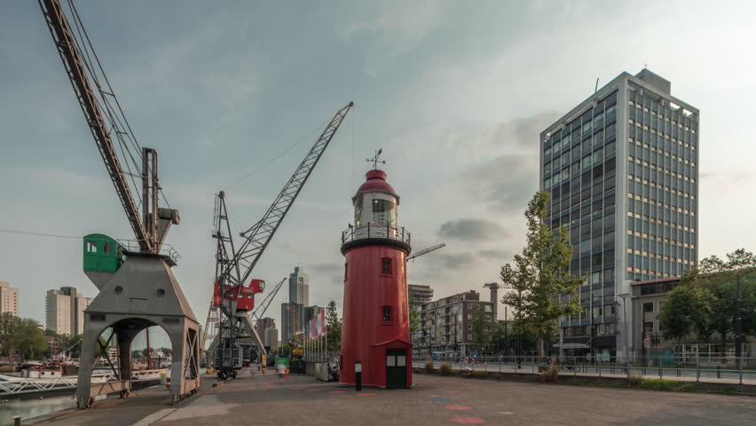 Hyperlapse of The Low Light of Hook of Holland in Rotterdam, Netherlands. Maritime Museum Harbor features historic vessels, cranes and an old lighthouse with skyscrapers in the background timelapse