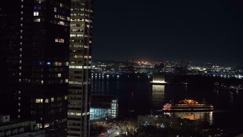 An enchanting and serene nighttime view of a vibrant cityscape featuring a brightly lit ferry moving across the water. Staten island ferry in New York.