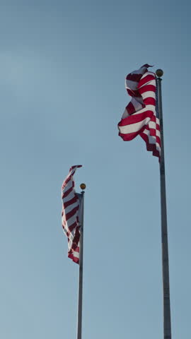 A magnificent and stunning array of American flags is waving proudly and gracefully in the gentle breeze outside