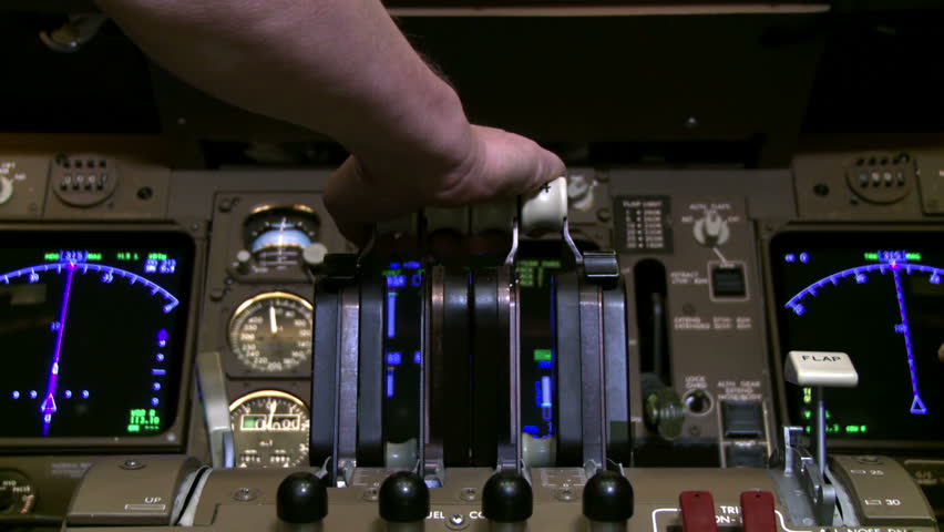 Detail of 747 pilot's hand as he pulls back on jet throttles while plane is on
