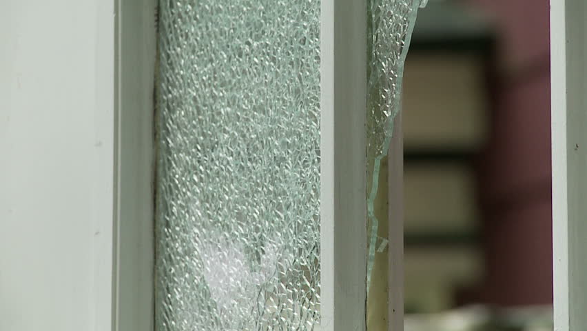 Hammer bursts through shattered safety glass. Recorded in slow motion