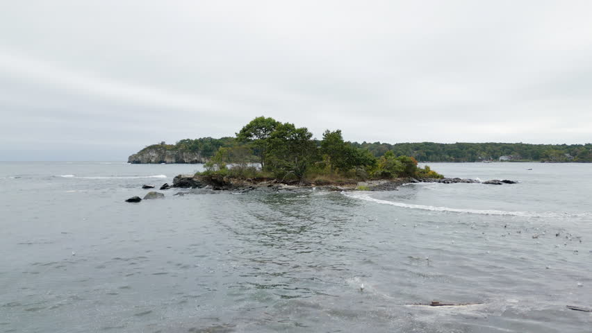 Peaks Island near Portland, Maine, sits in calm waters on an overcast day with gentle waves.