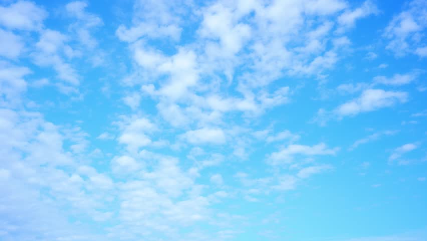 4K : Time-lapse video captures the fluffy white clouds across a serene blue sky, the dynamic beauty of the atmosphere. Cloud formations concept. Timelapse. Sky background.
