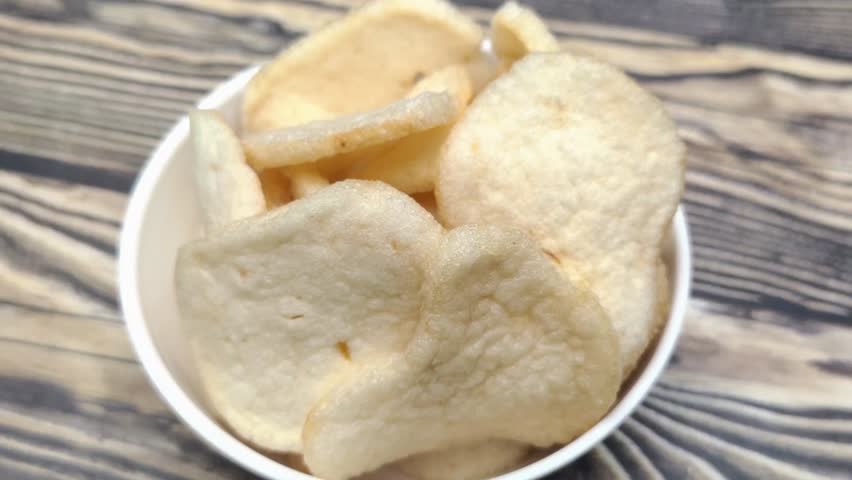 A pile of shrimp crackers in a small bowl. Shrimp crackers are made from a mixture of tapioca flour and finely pounded shrimp with spices and flavor enhancers. A snack from Sidoarjo, Indonesia.