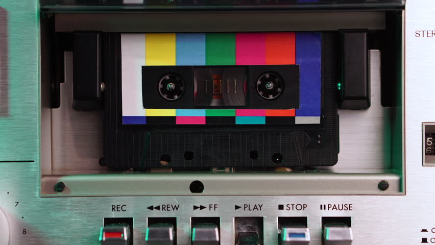 Audio Cassette Tape With Colorful Label Design Playing in Vintage Deck From 1980's, Close Up