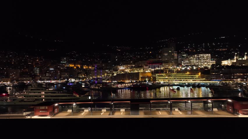 Aerial establishing shot of the Montel Carlo port at night underlights