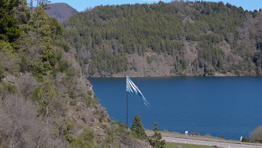 Argentine flag flying on iconic Route 40 on shores of Lácar lake in San Martín de Los Andes, Neuquén, Patagonia Argentina