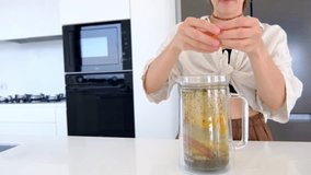 woman makes herbal tea in her kitchen. She adds leaves of mint, lemon balm, thyme, and rosemary to teapot . woman enjoys delicious and aromatic beverage. - Powered by Shutterstock - Get 15% off with code: PIKWIZARD15