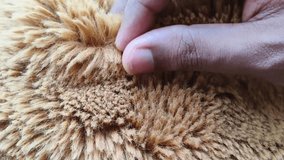 Hand fingers gentle touch and feel fluffy hairy brown fake fur imitation for checking material quality. Luxury winter seasonal fashion concept. Closeup macro top view. - Powered by Shutterstock - Get 15% off with code: PIKWIZARD15