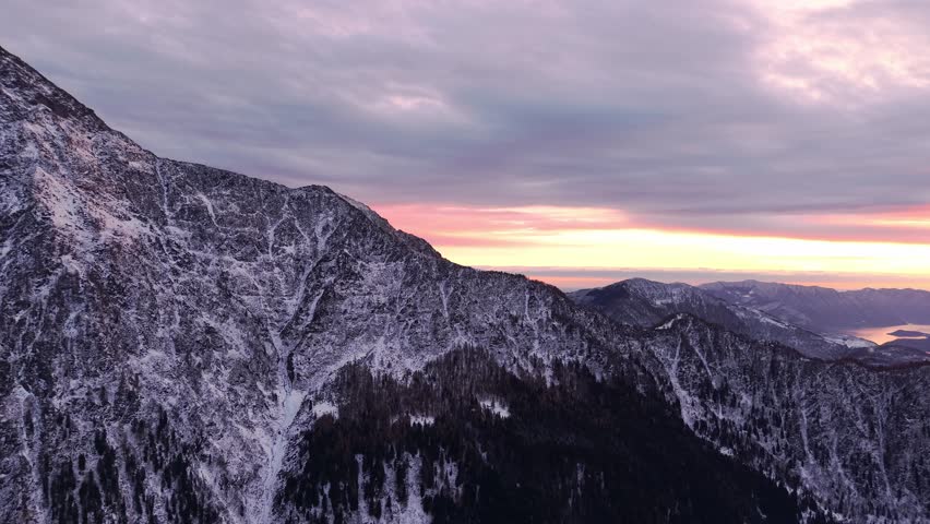Snowy mountain peaks at sunrise with soft pastel skies over the scenic Italian Alps