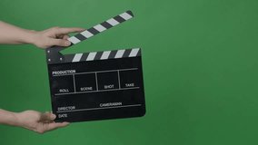 Movie Clapper board clapped by Hands on green screen camera background. Filmmaker hit film slate on green camera frame. Clapperboard Chroma key suit shooting. Green screen composite video production. - Powered by Shutterstock - Get 15% off with code: PIKWIZARD15