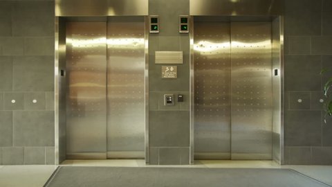 Empty elevator arrives, doors open and close. Wide, locked off shot.