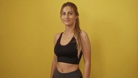 Woman with crossed arms standing against a bright yellow background, blonde hair and athletic outfit highlighting her confidence and casual style. - Powered by Shutterstock - Get 15% off with code: PIKWIZARD15