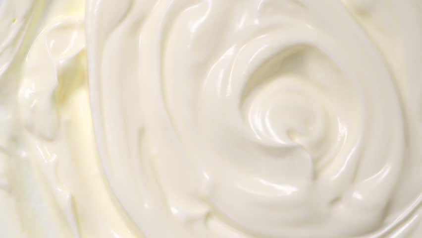 Sour cream or greek yogurt swirl, rotating texture, White cream background, close up. Dairy product. Delicious organic creamy yogurt. Milk cream. Top view, Macro shot. 
