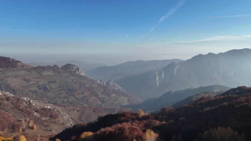 Drone footage of hills and rocky cliffs with interesting shapes during the season of colors, fall.