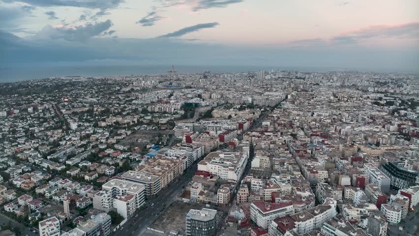 Panoramic 4K drone view of Casablanca, featuring the Hassan II Mosque, cityscape, boulevards, villas, and ocean. A stunning blend of modern and traditional architecture in Morocco.