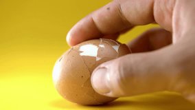 Cracking of a hard boiled egg on a yellow background - Powered by Shutterstock - Get 15% off with code: PIKWIZARD15