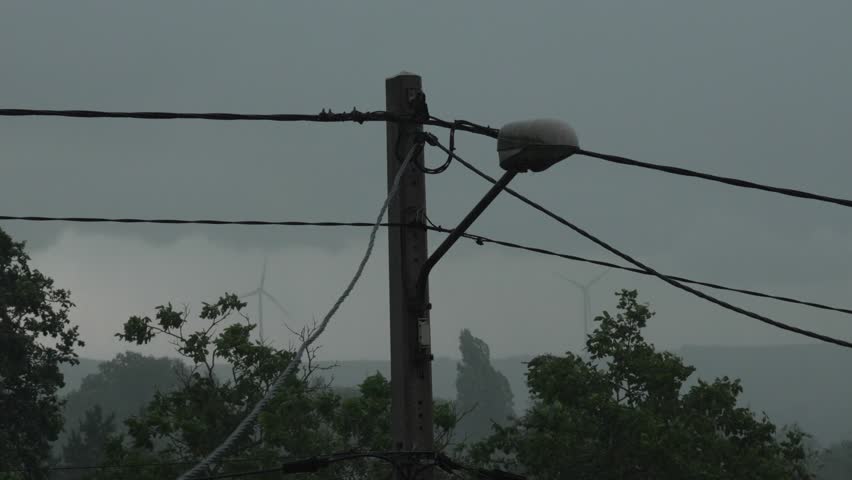 Storm clouds high wind bad weather rural wood electricity pole post, grey sky