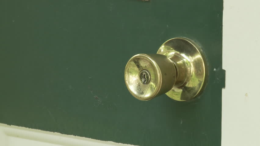 Hand reaches in from above, turns a brass handle and opens a green door.