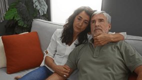 Middle-aged couple sitting together lovingly in an indoor home setting, conveying warmth and intimacy within a cozy living room. - Powered by Shutterstock - Get 15% off with code: PIKWIZARD15