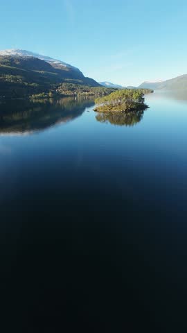 Small island in the center of lake in the mountains of Norway