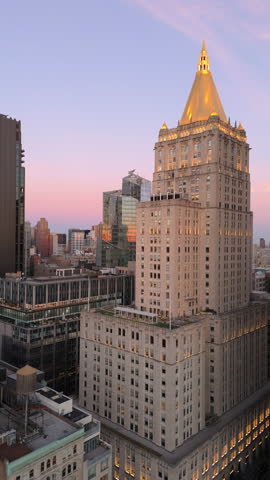 Vertical views of New York City skyline emerge during a stunning sunset, showcasing New York Life Building in Rose Hill and NoMad neighborhoods of Manhattan