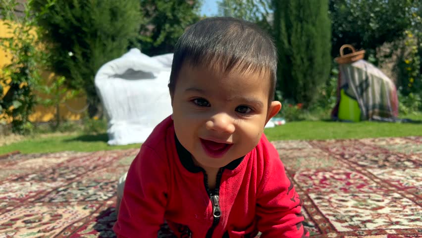 Muslim new born boy in an open air park smiling, looks beautiful an Indian organ face. A healthy boy child