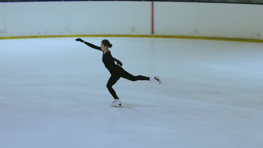 Figure skating girl on professional ice arena.