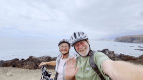 Two happy old mature people enjoying and riding bikes together to be fit and healthy outdoors. Active seniors having fun taking a selfie picture with camera - Powered by Shutterstock - Get 15% off with code: PIKWIZARD15