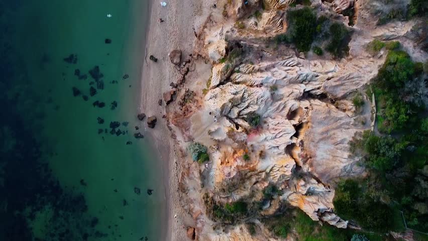A bird’s-eye view of Red Bluff cliffs, showcasing their dramatic rock formations and rugged coastline, with the ocean stretching into the distance.