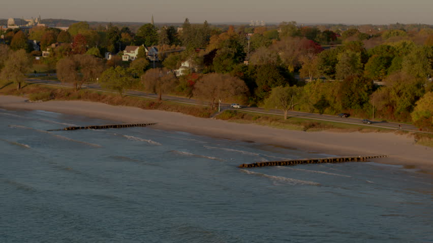 Cinematic aerial of Lake Michigan at sunrise with slow push in towards the shore in Autumn in Sheboygan, Wisconsin.