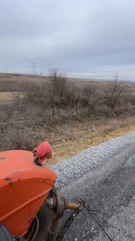 orange tractor driving on the road