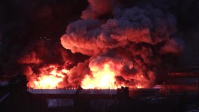 Orange toxic smoke from flames or fires of warehouses and industrial building at night. Burning house or adjacent area requiring the arrival of fire and rescue personnel due to fire safety violations. - Powered by Shutterstock - Get 15% off with code: PIKWIZARD15