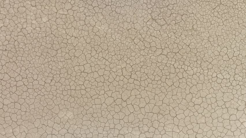 Aerial shot looking down at the cracked surface of a dry lake.